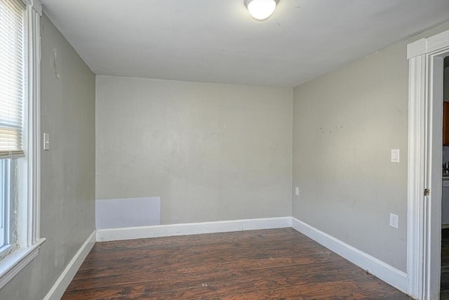 spare room with wood finished floors, baseboards, and a wealth of natural light