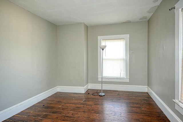 empty room featuring baseboards and wood-type flooring