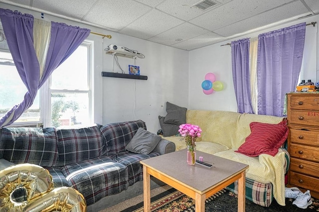 living area with visible vents and a paneled ceiling