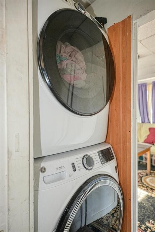 clothes washing area featuring laundry area and stacked washing maching and dryer