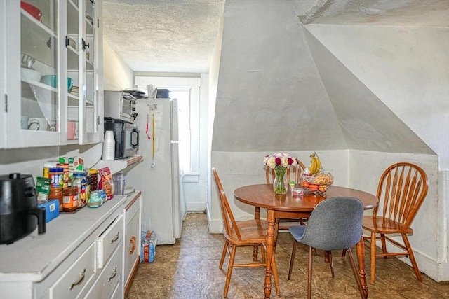 dining room with tile patterned floors and a textured ceiling