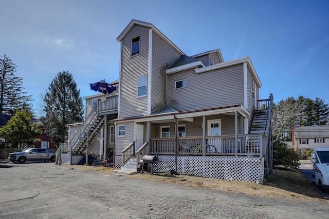 view of front of property featuring stairway and a porch