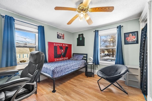 bedroom featuring a textured ceiling, ceiling fan, and light hardwood / wood-style floors