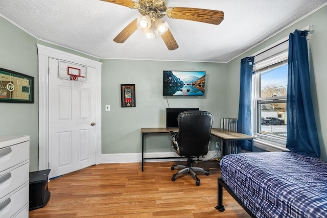 bedroom featuring ceiling fan, light hardwood / wood-style flooring, and a textured ceiling