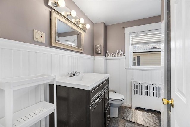 bathroom featuring vanity, radiator heating unit, and toilet