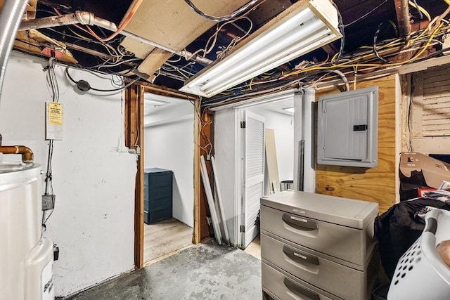 basement with electric panel, water heater, and wood walls