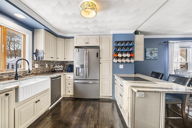 kitchen with light stone countertops, appliances with stainless steel finishes, sink, and a kitchen breakfast bar