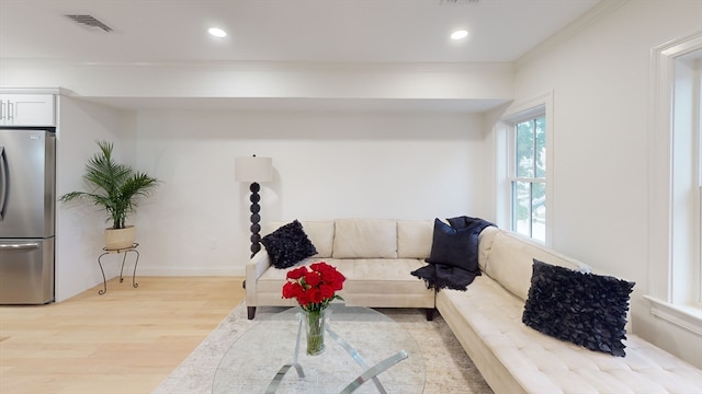 living room with light hardwood / wood-style floors and crown molding