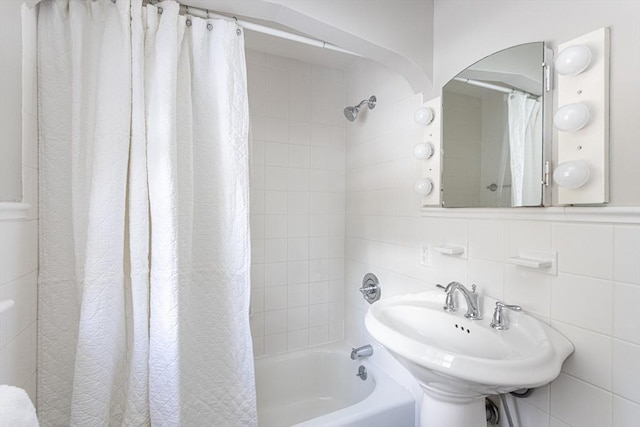 bathroom featuring shower / bath combo with shower curtain, sink, and tile walls