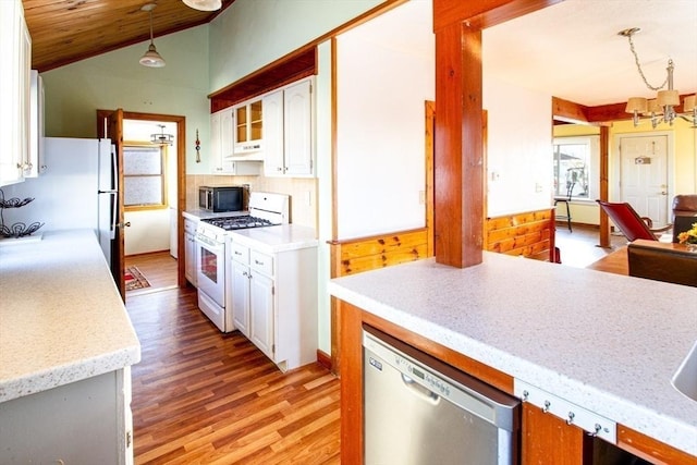 kitchen with white appliances, hanging light fixtures, vaulted ceiling, white cabinetry, and a chandelier