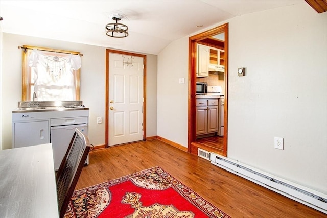 interior space with tasteful backsplash, light hardwood / wood-style flooring, a baseboard heating unit, stove, and lofted ceiling