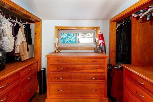 walk in closet with dark hardwood / wood-style flooring and vaulted ceiling