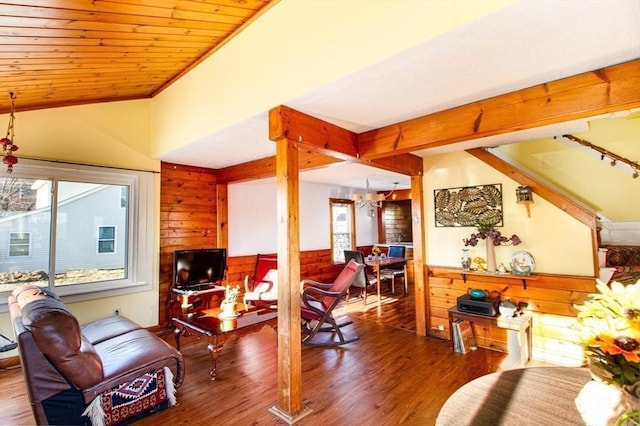 living room featuring wood-type flooring, a wealth of natural light, a notable chandelier, and wood walls