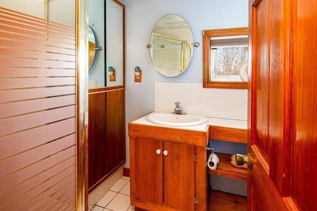 bathroom featuring tile patterned flooring, vanity, and decorative backsplash