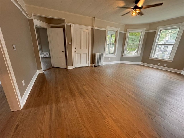 19 Chapel St, Shirley, MA 01464 - unfurnished living room featuring radiator heating unit, ornamental molding, a ceiling fan, and wood finished floors