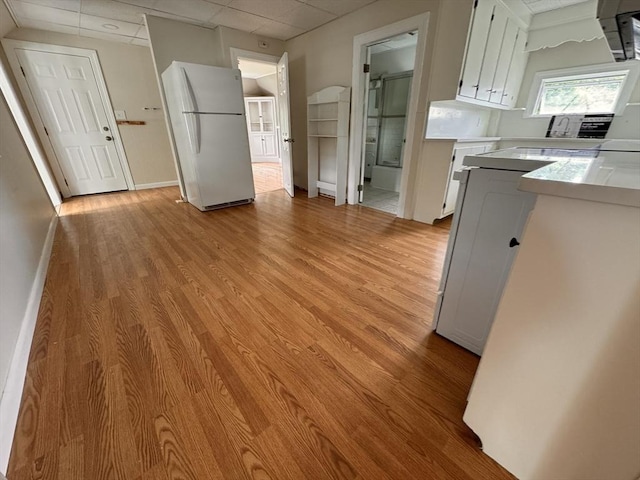 19 Chapel St, Shirley, MA 01464 - kitchen featuring freestanding refrigerator, a drop ceiling, light wood-style flooring, light countertops, and white cabinets