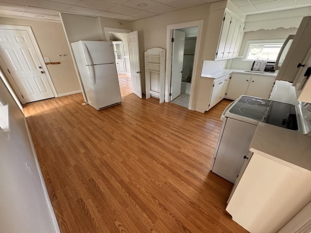 19 Chapel St, Shirley, MA 01464 - kitchen featuring white appliances, a drop ceiling, light countertops, white cabinets, and light wood-style floors