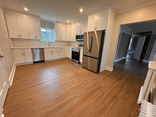 19 Chapel St, Shirley, MA 01464 - kitchen featuring stainless steel appliances, ornamental molding, white cabinets, light countertops, and light wood-style flooring