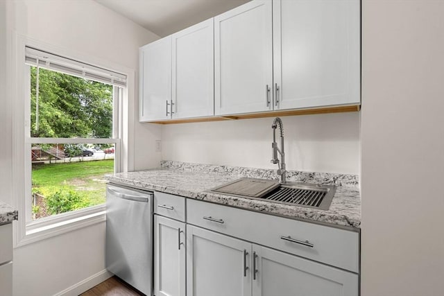 50 Howard St, Haverhill, MA 01830 - kitchen with stainless steel dishwasher, plenty of natural light, white cabinets, and light stone counters