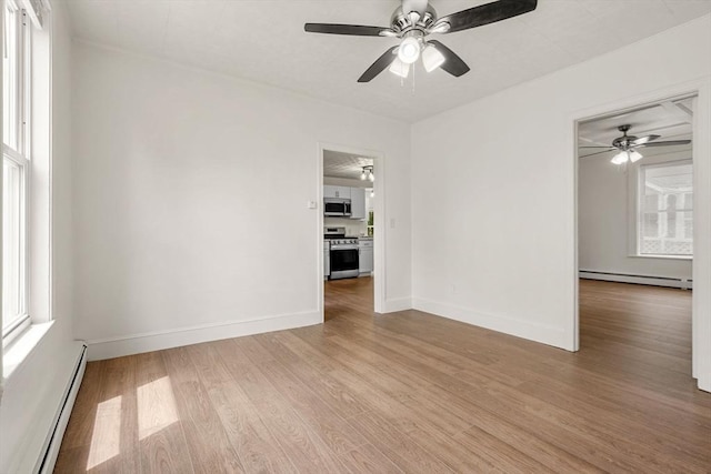 50 Howard St, Haverhill, MA 01830 - empty room with a baseboard heating unit, light wood-style floors, and a ceiling fan
