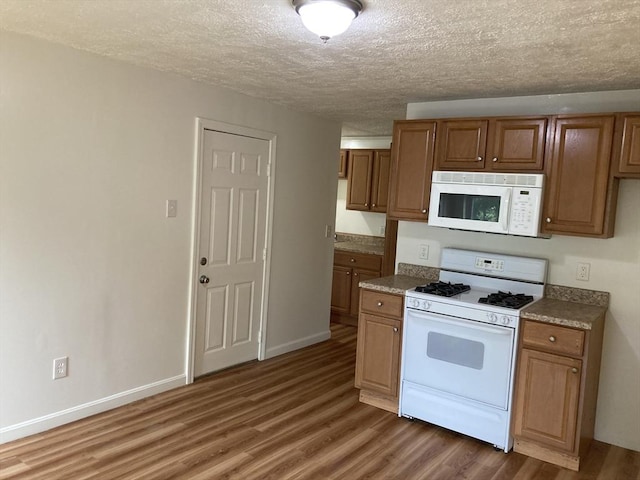50 Howard St, Haverhill, MA 01830 - kitchen featuring white appliances, wood finished floors, a textured ceiling, and brown cabinets