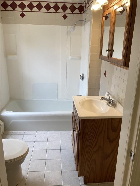 50 Howard St, Haverhill, MA 01830 - full bath featuring tile walls, vanity, washtub / shower combination, and tile patterned flooring