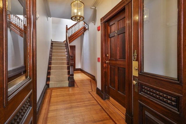 256 W Newton St Unit 1, Boston, MA 02116 - foyer entrance featuring light wood-style flooring, stairway, baseboards, ornamental molding, and a chandelier