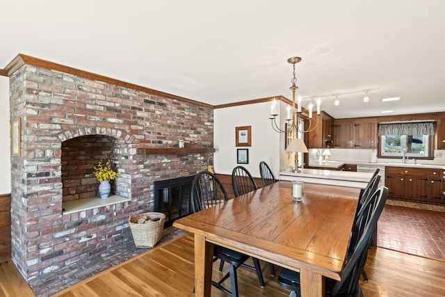 56 Fairwood Rd, Yarmouth, MA 02664 - dining room with wood finished floors, a brick fireplace, and a chandelier