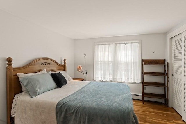 56 Fairwood Rd, Yarmouth, MA 02664 - bedroom featuring a baseboard heating unit, wood finished floors, and a closet