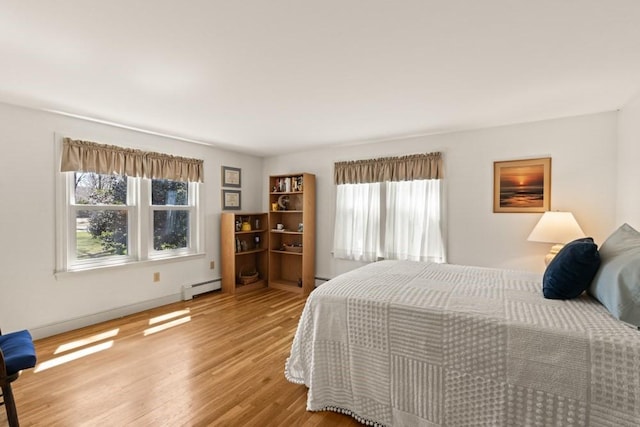 56 Fairwood Rd, Yarmouth, MA 02664 - bedroom with a baseboard heating unit, baseboards, wood finished floors, and multiple windows