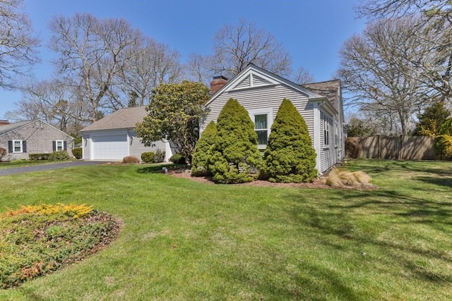 56 Fairwood Rd, Yarmouth, MA 02664 - view of front of property with a chimney, fence, a garage, and a front yard