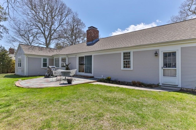 56 Fairwood Rd, Yarmouth, MA 02664 - rear view of house with a shingled roof, a patio area, a lawn, and a chimney