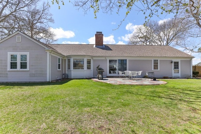56 Fairwood Rd, Yarmouth, MA 02664 - back of property with a chimney, roof with shingles, a patio, and a lawn