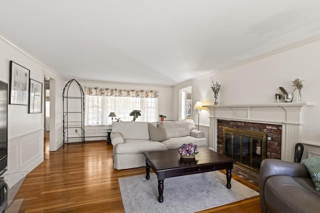 56 Fairwood Rd, Yarmouth, MA 02664 - living room featuring wood finished floors, a fireplace, and crown molding