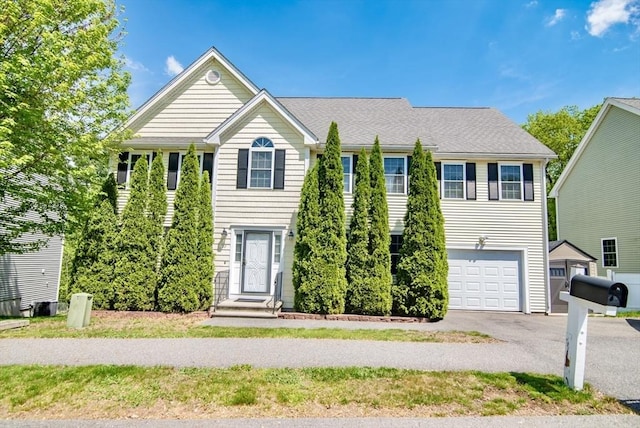 12 Kestrel Ln Unit 7, Westford, MA 01886 - view of front of property featuring an attached garage, cooling unit, and asphalt driveway