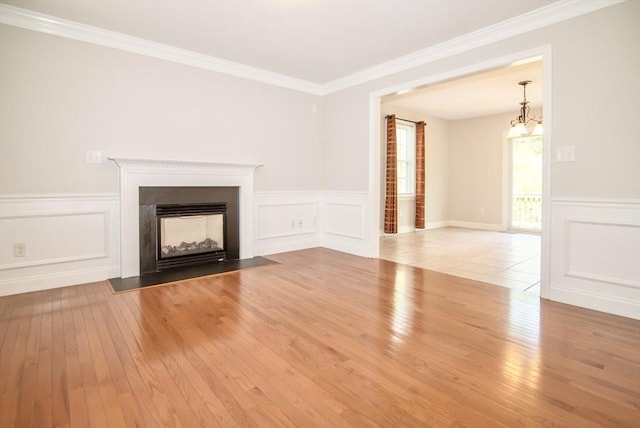 12 Kestrel Ln Unit 7, Westford, MA 01886 - unfurnished living room featuring wood-type flooring, a decorative wall, ornamental molding, a fireplace with flush hearth, and a wainscoted wall