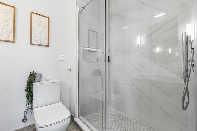 bathroom featuring toilet and a marble finish shower