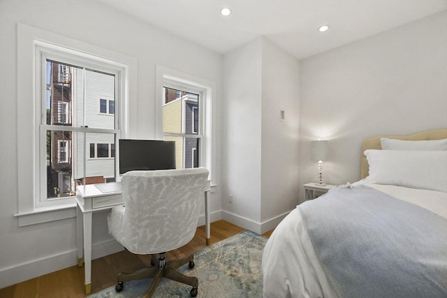 bedroom with baseboards, wood finished floors, recessed lighting, and an office area