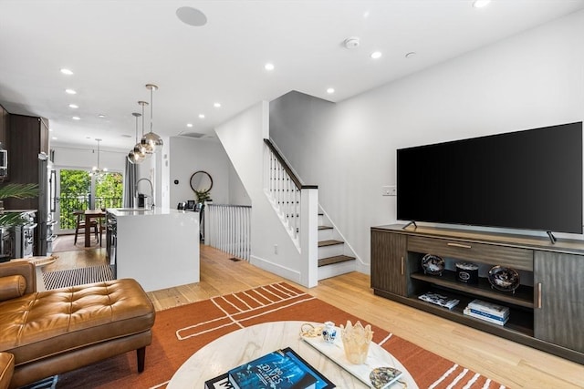 living area with light wood finished floors, stairs, recessed lighting, and baseboards