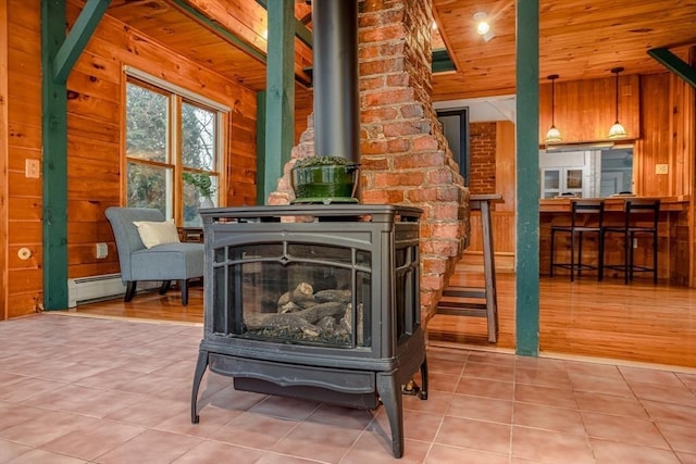 room details featuring wooden ceiling, a wood stove, baseboard heating, and wood walls