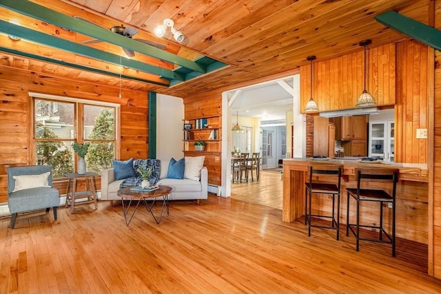 interior space with light wood-type flooring, wood ceiling, and wood walls