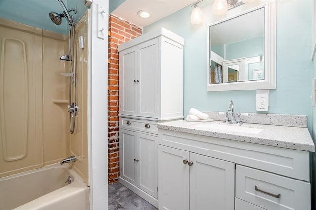 bathroom featuring brick wall, washtub / shower combination, and vanity