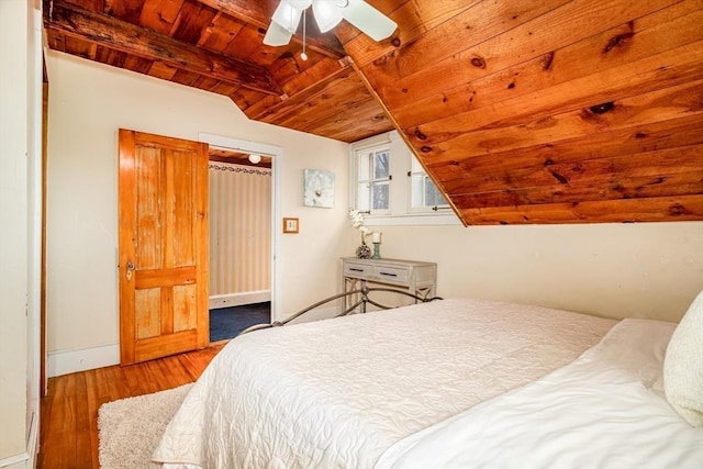 bedroom featuring ceiling fan, hardwood / wood-style floors, vaulted ceiling with beams, and wooden ceiling