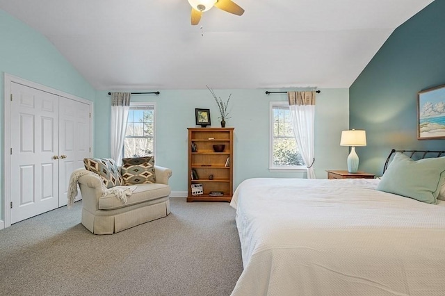 carpeted bedroom with vaulted ceiling, a closet, and ceiling fan