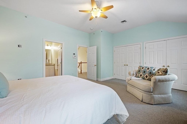 carpeted bedroom with lofted ceiling, two closets, ceiling fan, and ensuite bath