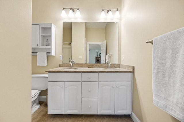 bathroom with tile patterned flooring, vanity, and toilet