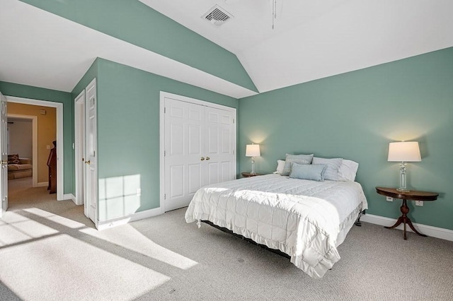 bedroom featuring vaulted ceiling, light carpet, and a closet