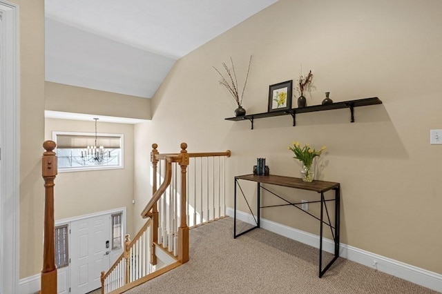 staircase featuring lofted ceiling, carpet, and a notable chandelier