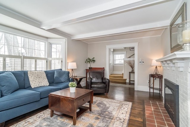 living room featuring dark wood-type flooring, beamed ceiling, and a brick fireplace