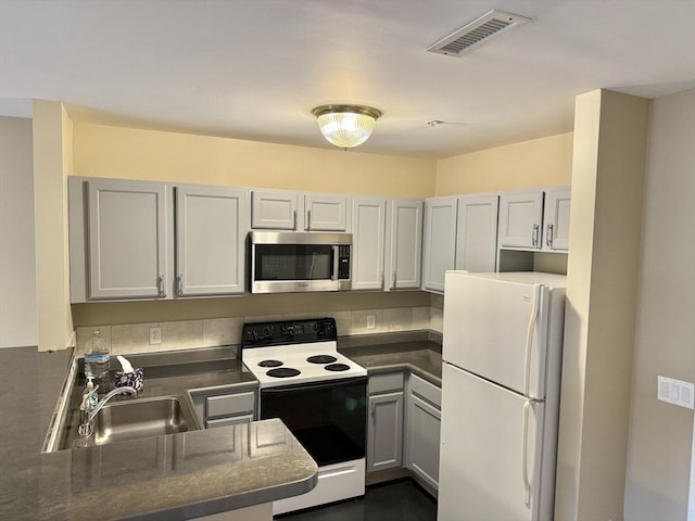 211 Central Unit A210, Norwood, MA 02062 - kitchen with stainless steel microwave, freestanding refrigerator, electric range, a sink, and dark countertops